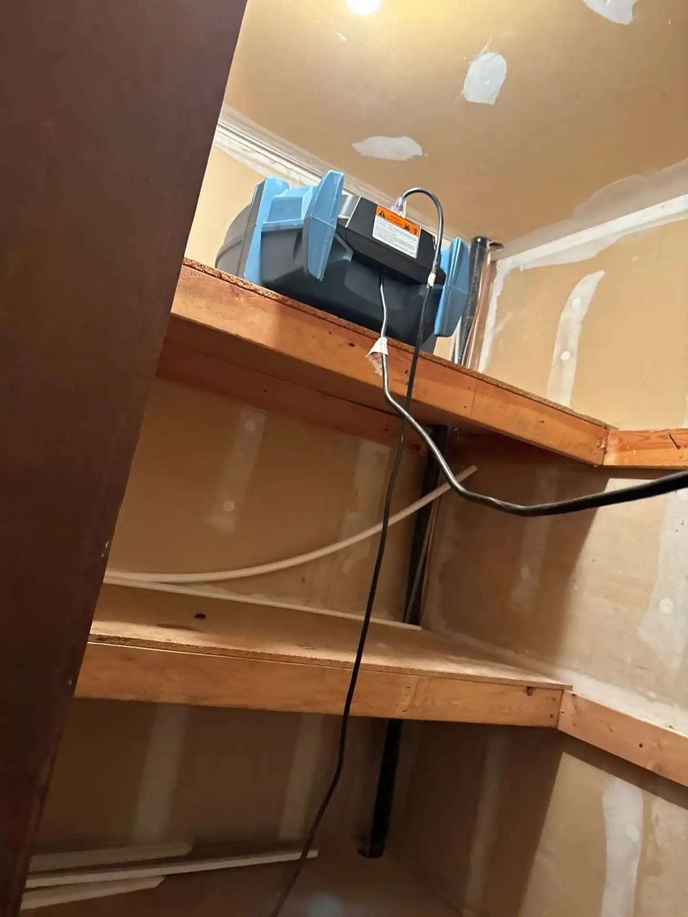 Dehumidifier drying the space under a staircase